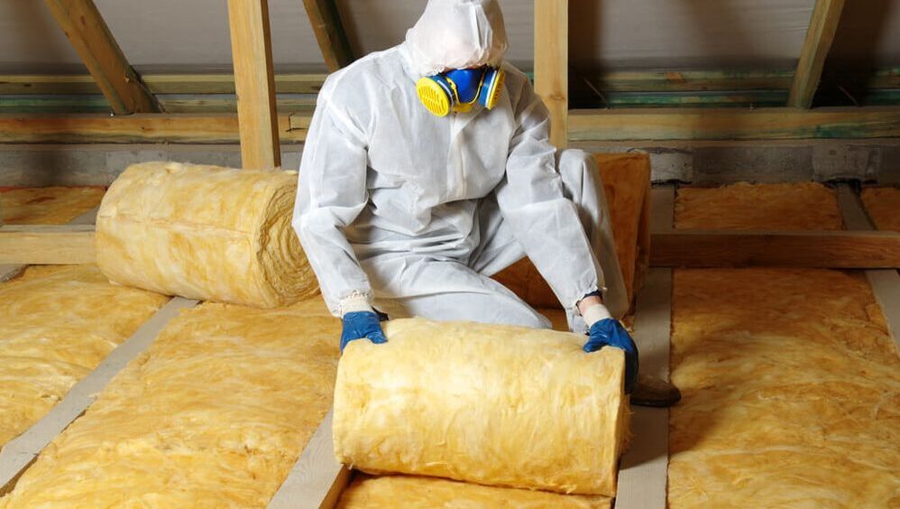 rolled glass wool being installed for attic insulation